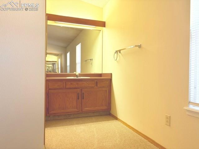Bathroom featuring vanity and light carpet