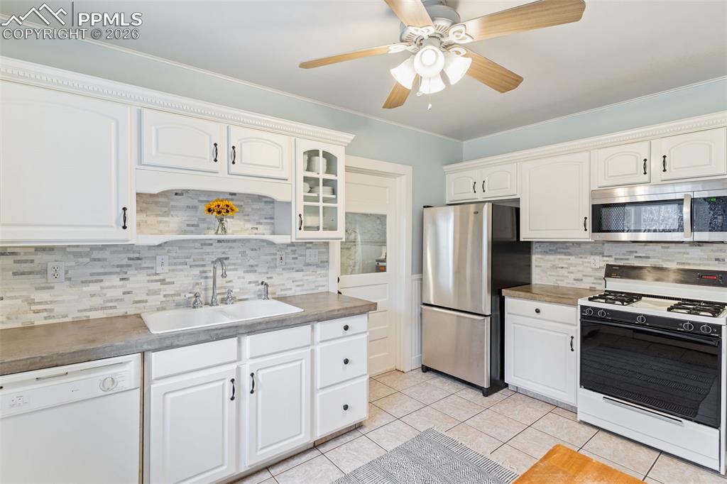 Inviting kitchen with tile floor and door that leads out to laundry, storage room, and breezeway to studio and garage.