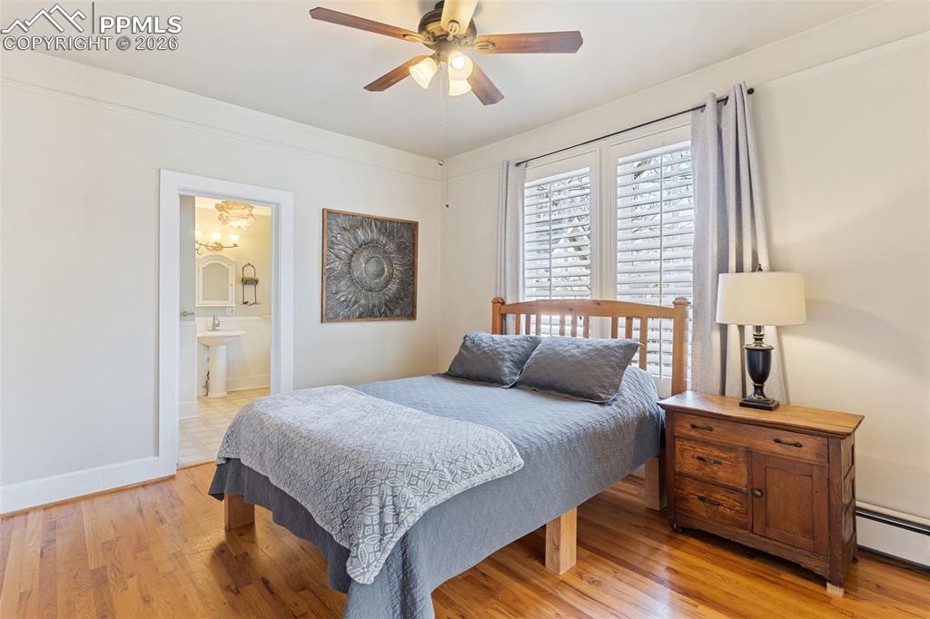 Large, beautiful primary bedroom with hardwood floors, high ceilings, attached full bathroom, and a sitting/office/dressing room.
