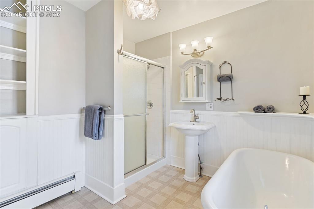 Graceful, spacious bathroom with claw foot tub and separate shower.