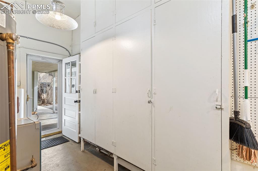 Utility room with an abundance of storage; door to covered breezeway that takes you to the studio and garage.