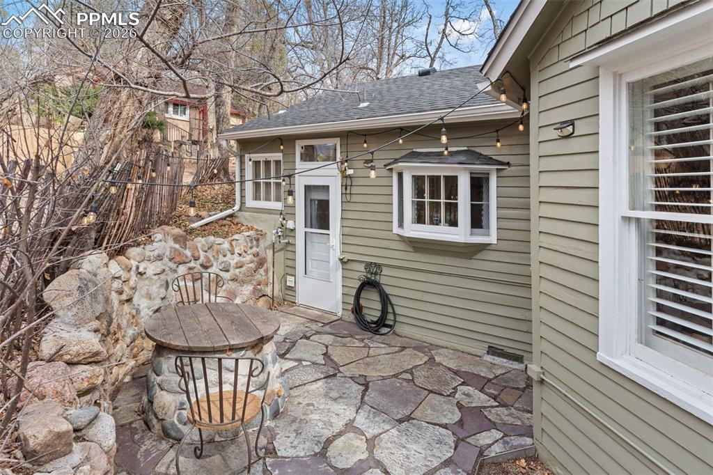 Side patio, with beautiful pavers, is off the kitchen and laundry room and is quietly tucked away (also has original old well/cistern).