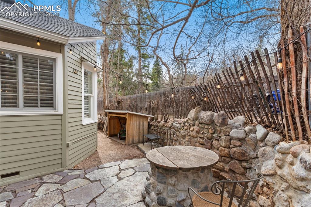 Side patio, with beautiful pavers, is off the kitchen and laundry room and is quietly tucked away (also has original old well/cistern).