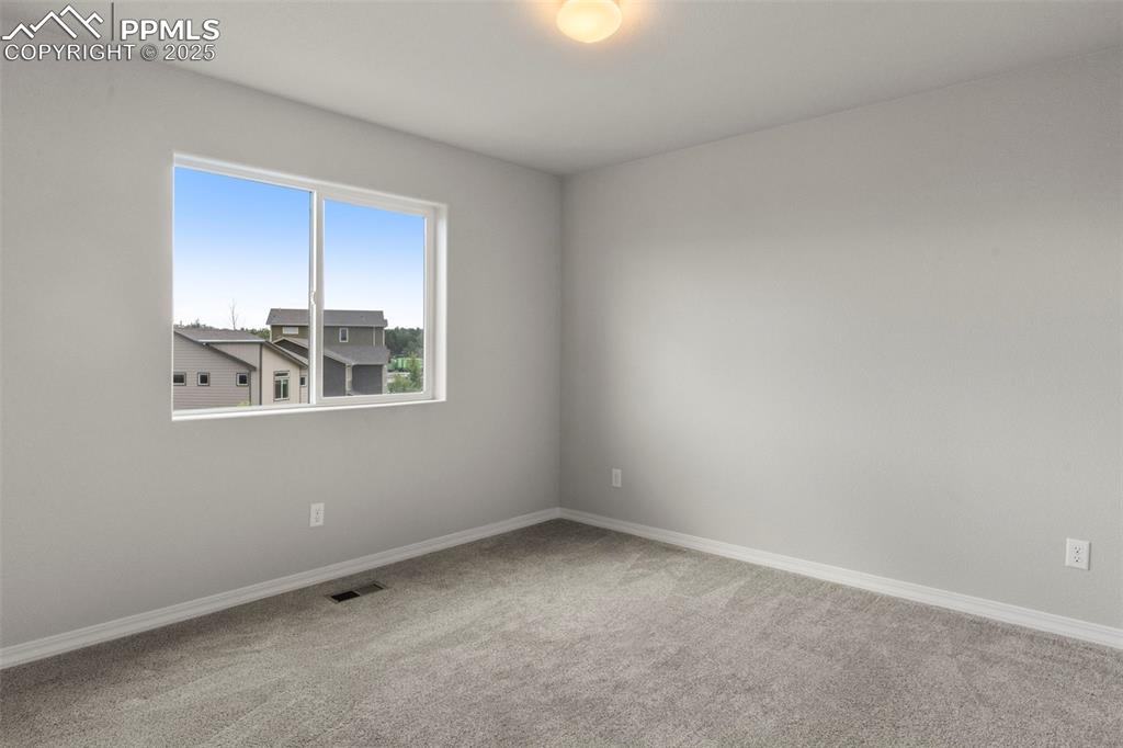 Spare room featuring carpet floors and baseboards