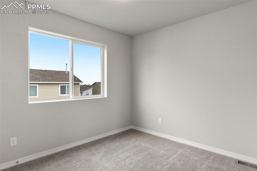 Empty room with light carpet and baseboards