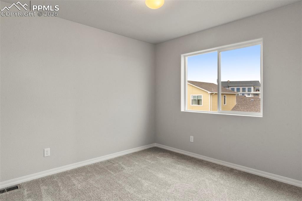 Spare room with baseboards and light carpet