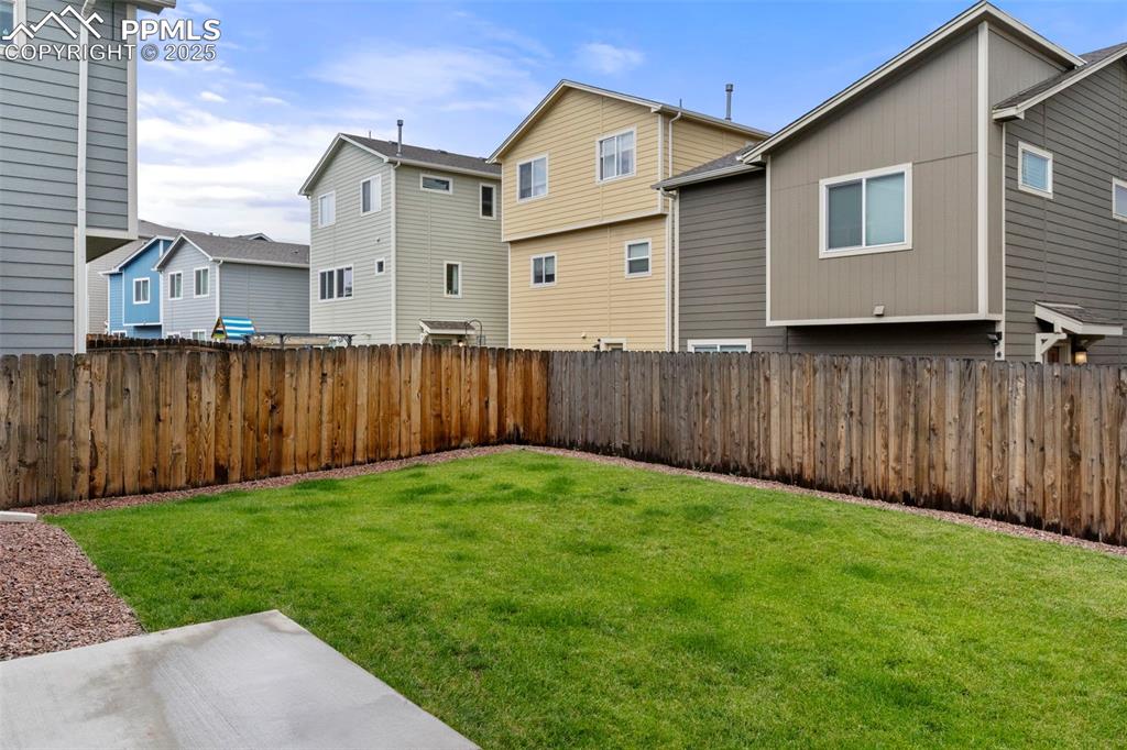 Fenced backyard featuring a residential view