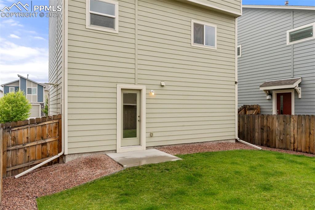 Back of house with a fenced backyard