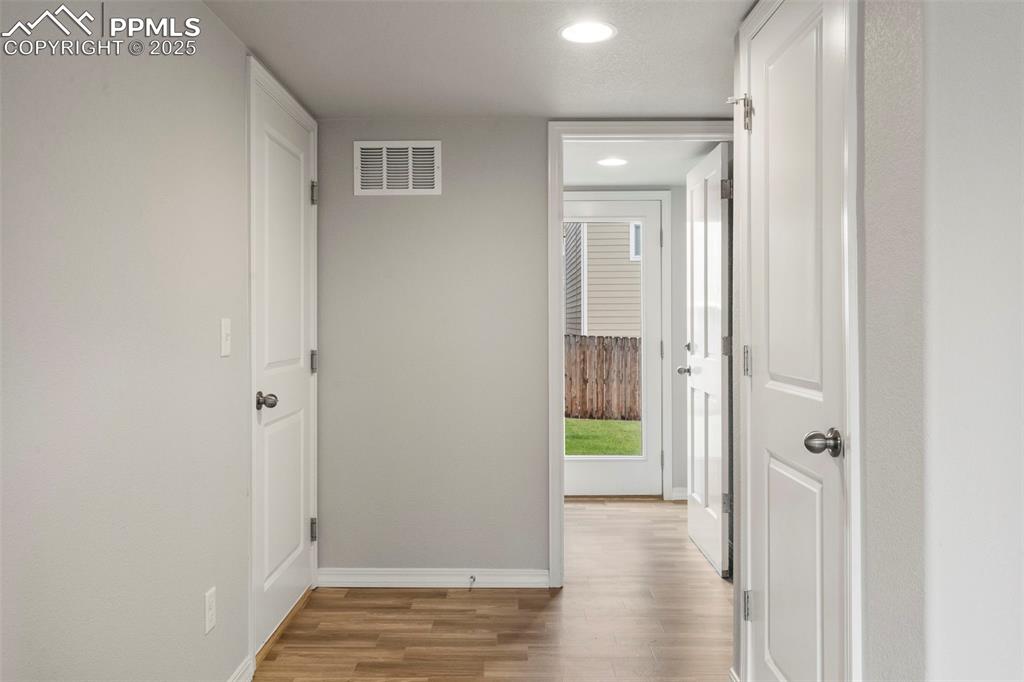 Corridor featuring light wood-style floors and recessed lighting