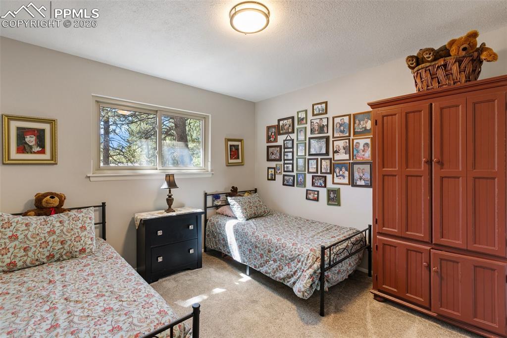 Bedroom featuring light carpet and a textured ceiling