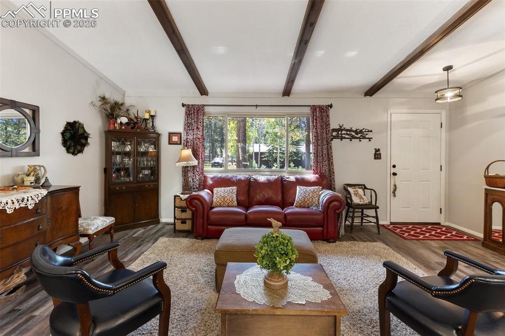 Living room featuring beamed ceiling and wood finished floors