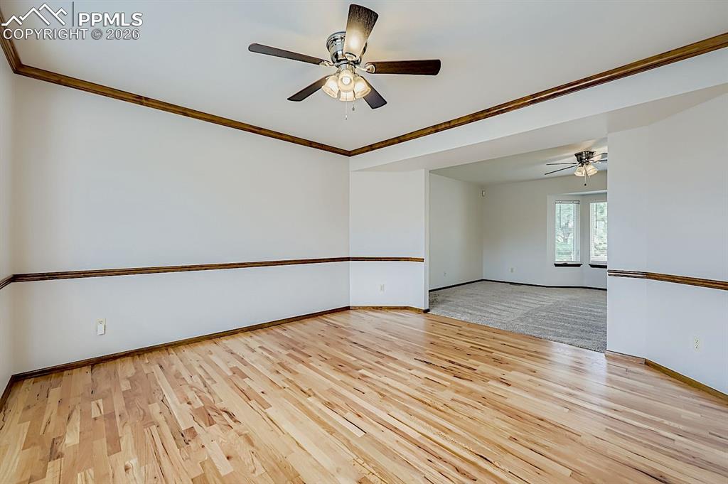 Spare room featuring ornamental molding, a ceiling fan, and light wood finished floors