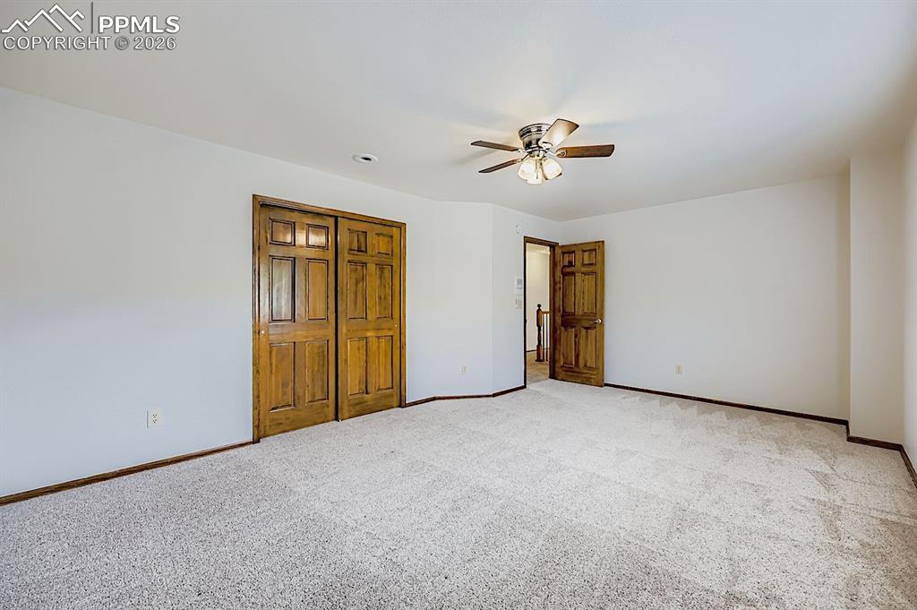Unfurnished bedroom featuring carpet floors, a ceiling fan, and a closet
