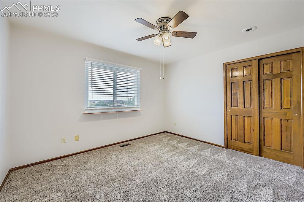 Unfurnished bedroom featuring a closet, carpet, and ceiling fan