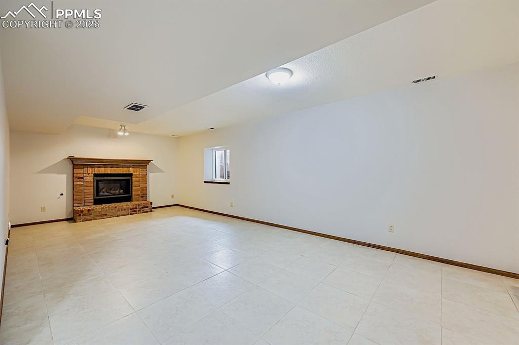 Unfurnished living room featuring a fireplace and light tile patterned floors