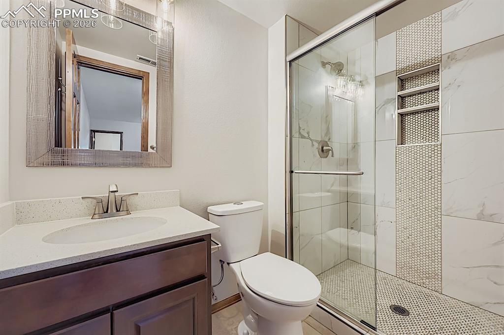 Full bathroom featuring a stall shower and vanity