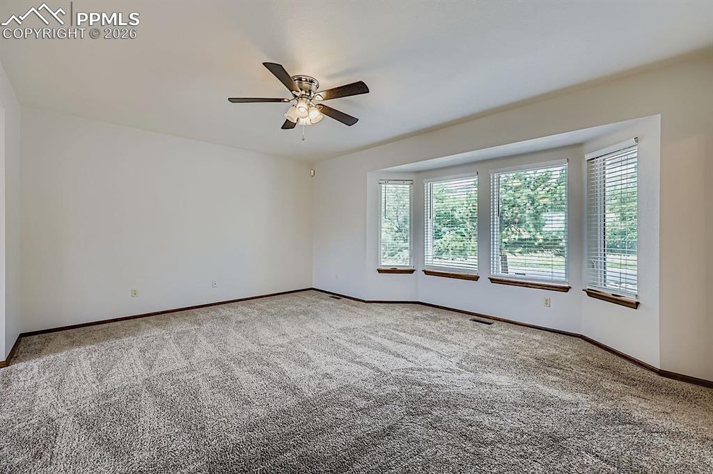 Empty room with carpet and ceiling fan
