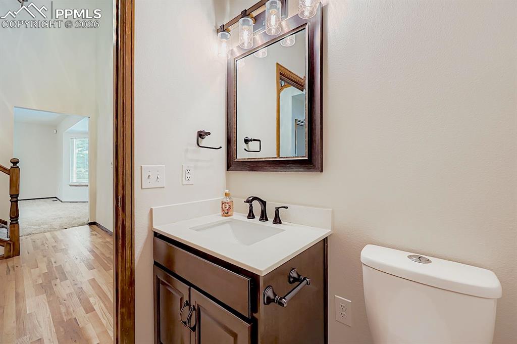 Half bath with vanity and light wood-type flooring