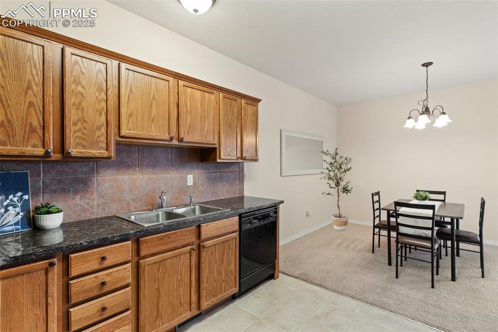 Kitchen featuring tasteful backsplash, brown cabinets, and dishwasher