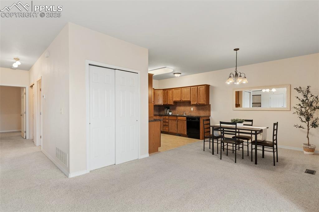 Dining area with light carpet and a chandelier