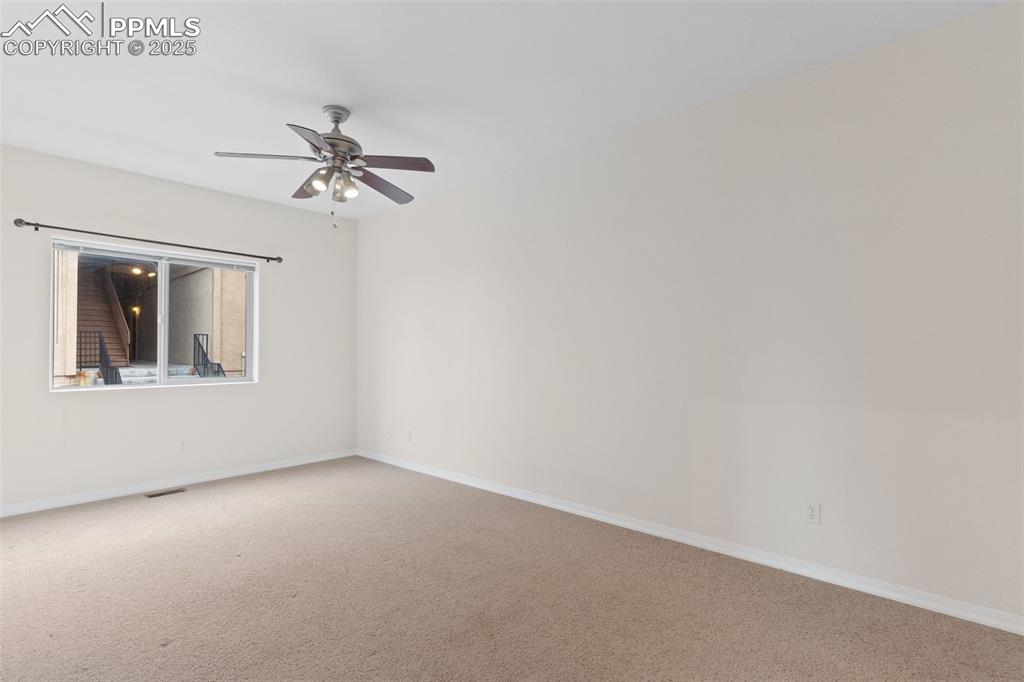 Empty room featuring carpet and ceiling fan