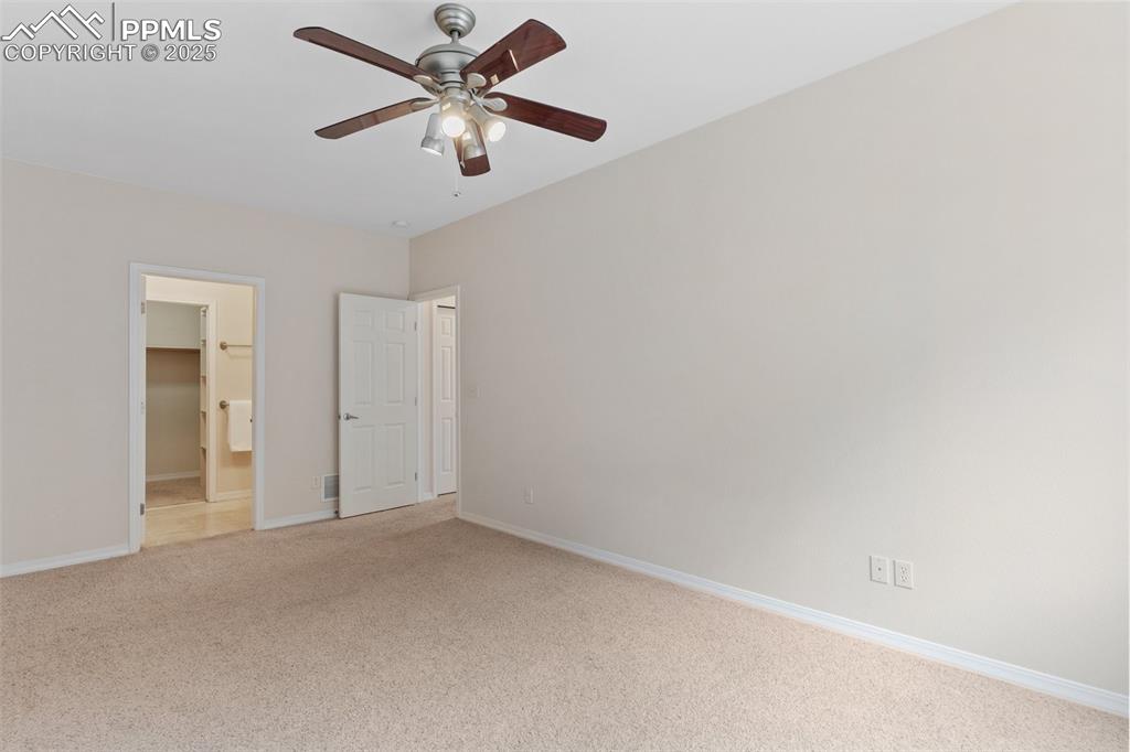Unfurnished bedroom with carpet floors, ceiling fan, and ensuite bathroom