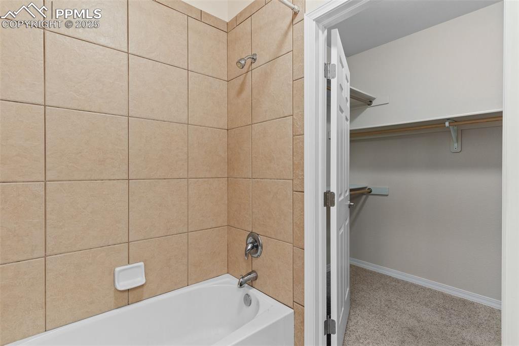 Full bathroom featuring bathing tub / shower combination and a spacious closet