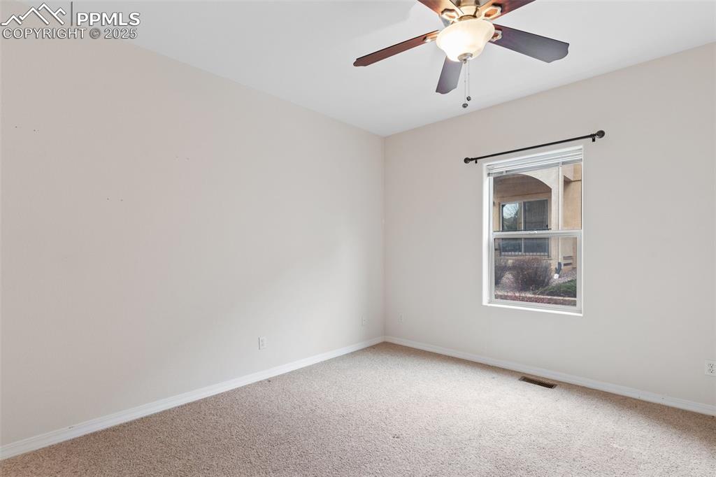 Spare room with carpet and a ceiling fan