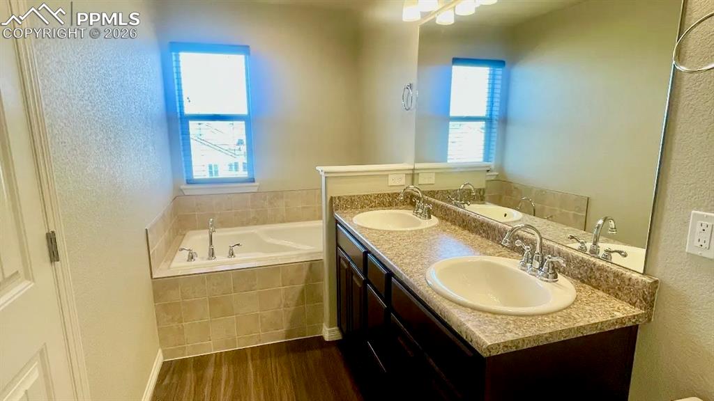 Spacious primary bathroom with dual vanities and soaking tub