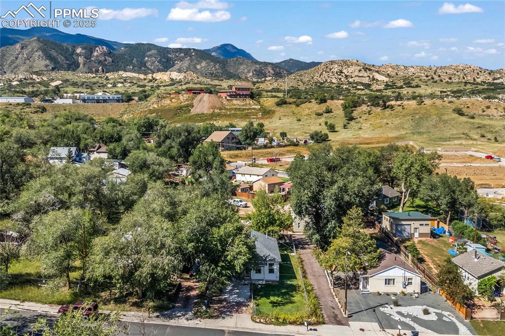 Aerial overview of property's location with a mountainous background and nearby suburban area