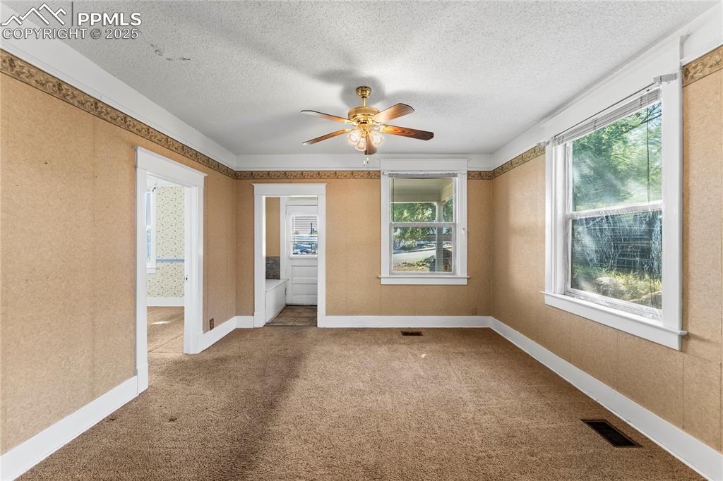 Unfurnished room with carpet floors, a textured ceiling, and a ceiling fan