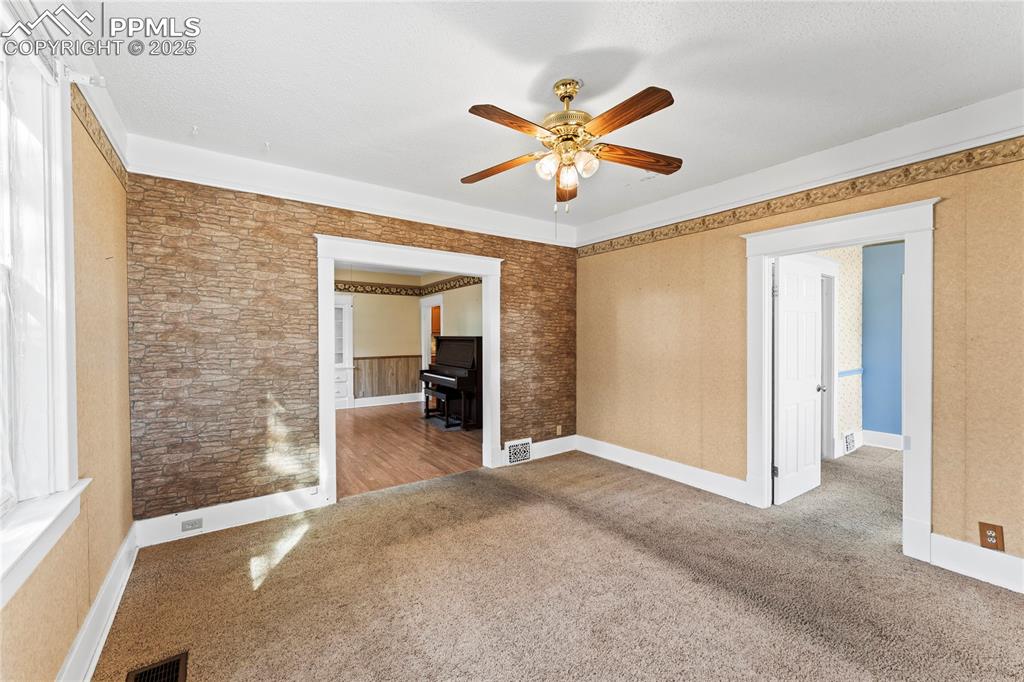 Unfurnished room with carpet floors and a ceiling fan