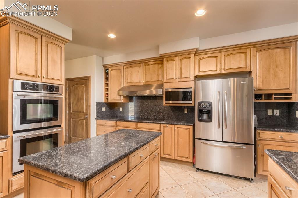 Kitchen with center island, custom appliances, cabinets and pantry. 