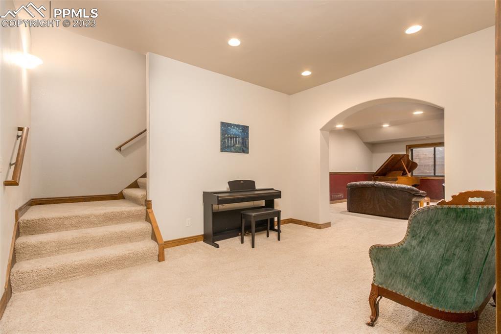 Oversized staircase enters the basement sitting area. 