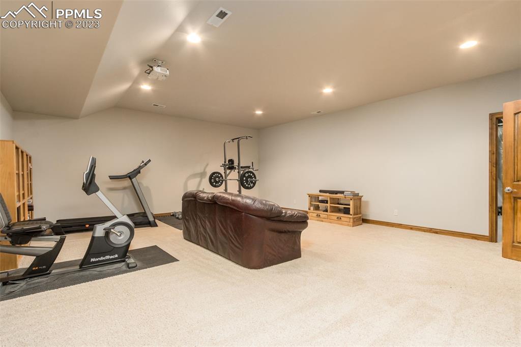 Fantastic theatre room with projector, projector pain on wall, and plenty of room to double as workout area. 