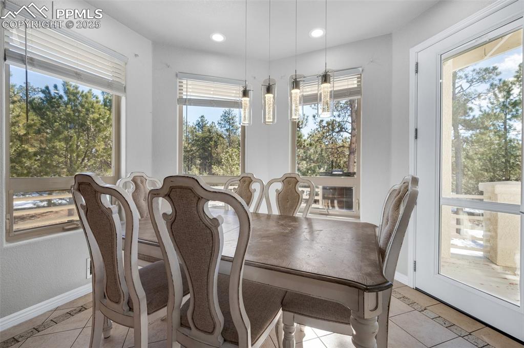 Dining space with light tile patterned flooring, recessed lighting, and baseboards