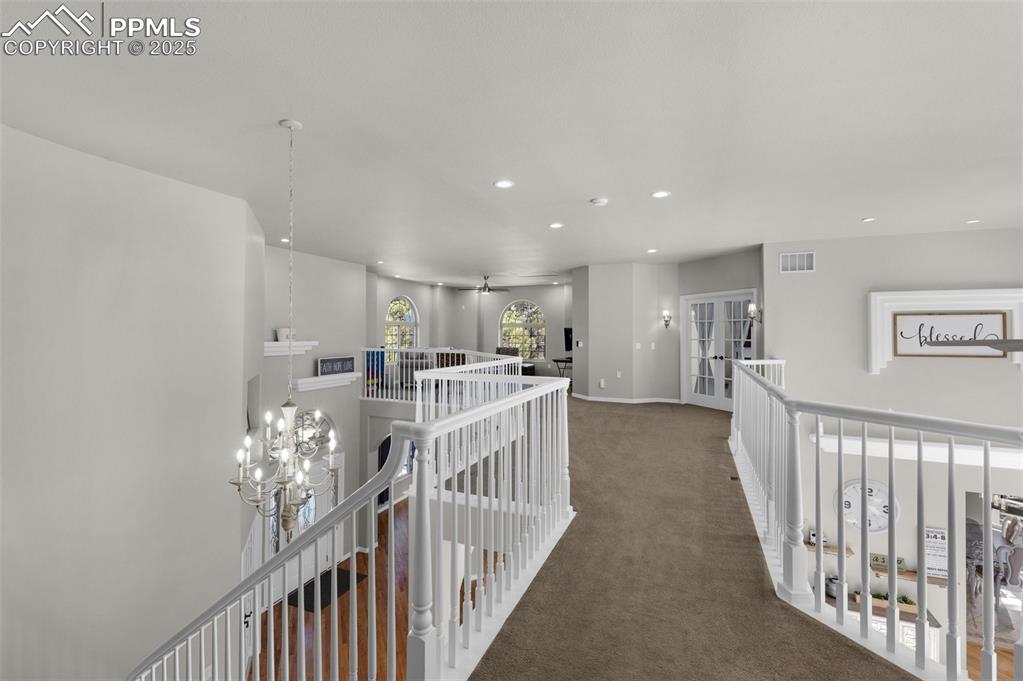 Hallway with visible vents, an upstairs landing, recessed lighting, carpet flooring, and baseboards