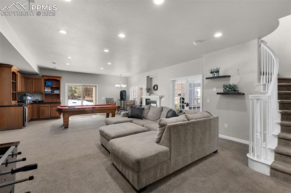 Living area with recessed lighting, stairs, pool table, a textured ceiling, and light colored carpet
