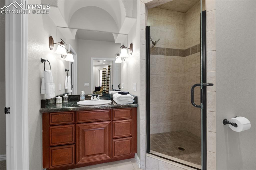 Full bath featuring a shower stall and vanity