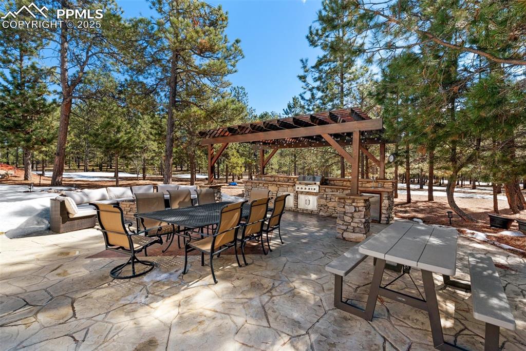 View of patio / terrace with a grill, outdoor dining area, and an outdoor kitchen