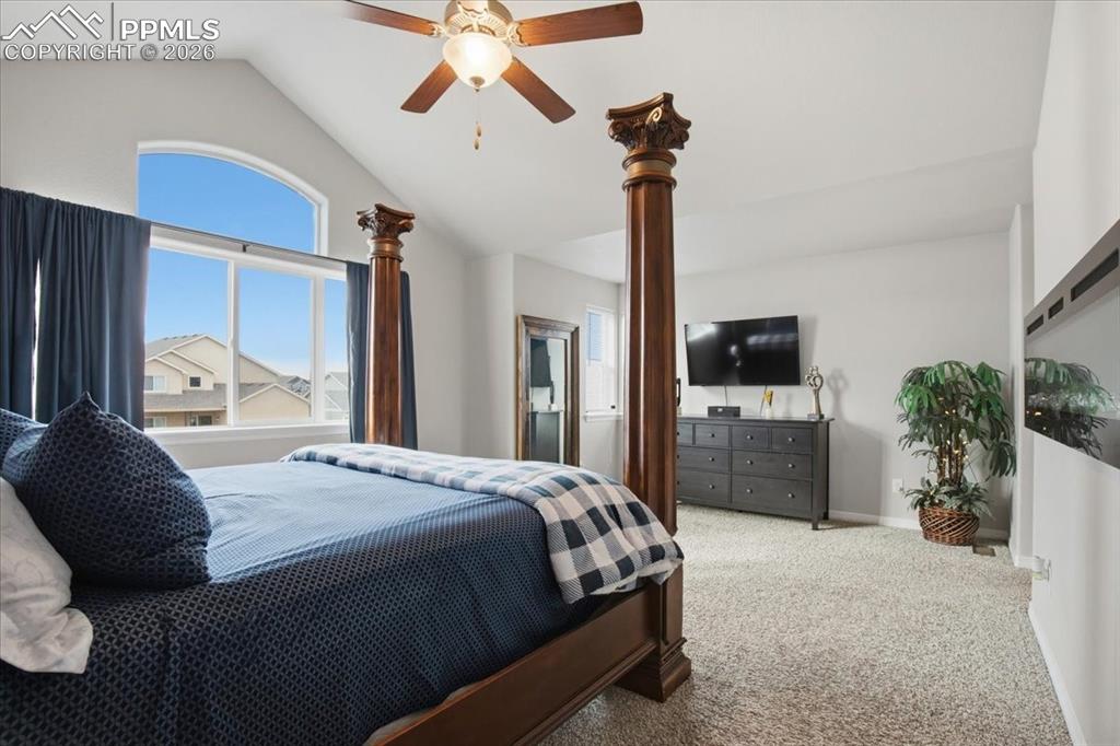 Spacious primary bedroom retreat with large windows, ceiling fan, and peaceful natural light