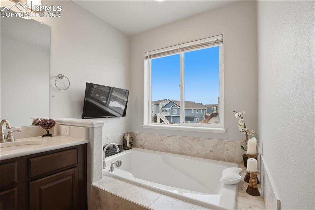 Primary bathroom featuring a soaking tub with tv creating a relaxing retreat 