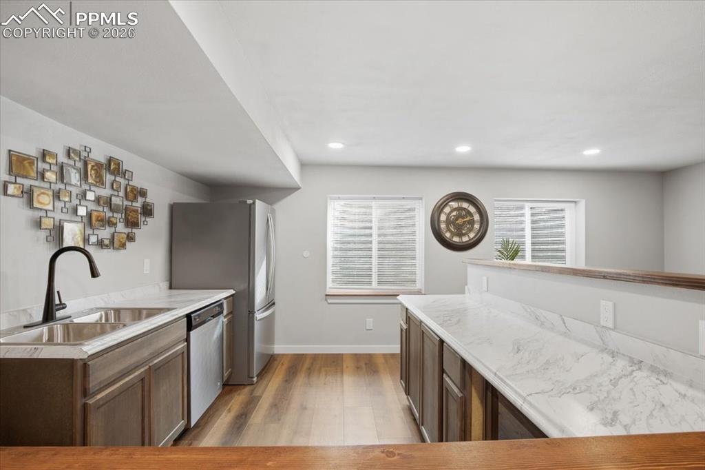 Basement wet bar featuring full size stainless steel refrigerator, sink, garbage disposal, Dishwasher, and microwave