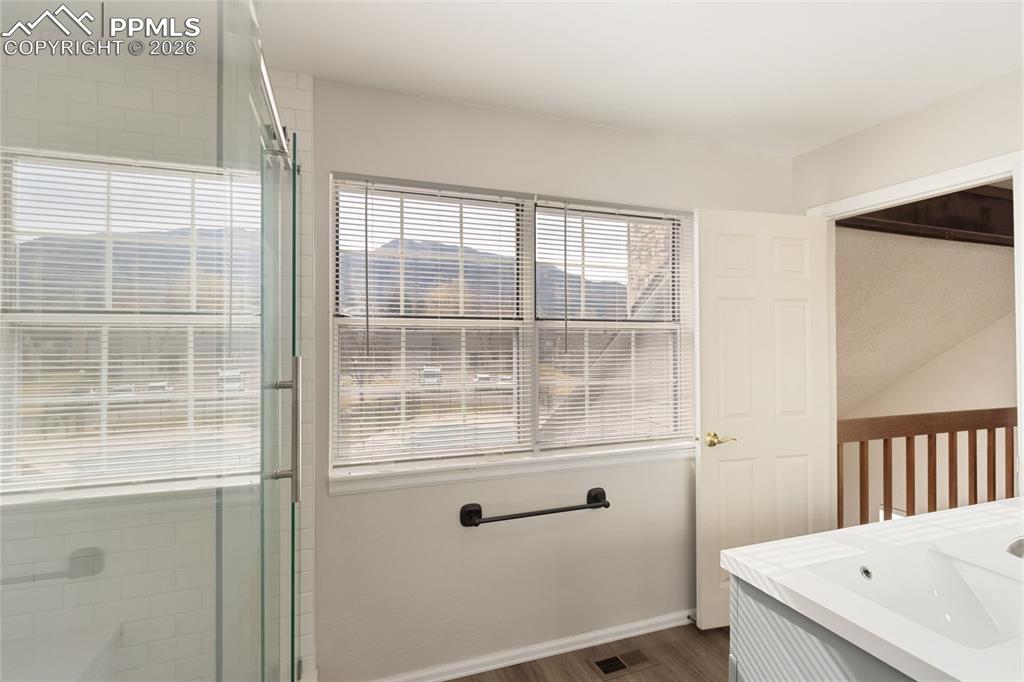 Bathroom featuring double vanity and free-standing shower with barn door