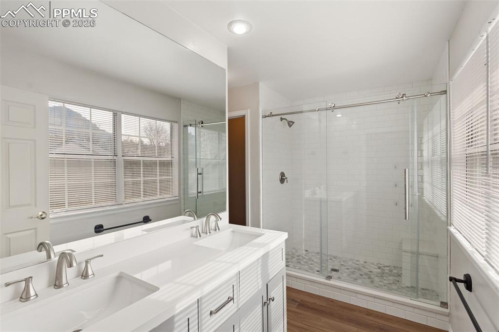 Bathroom featuring double vanity and free-standing shower with barn door