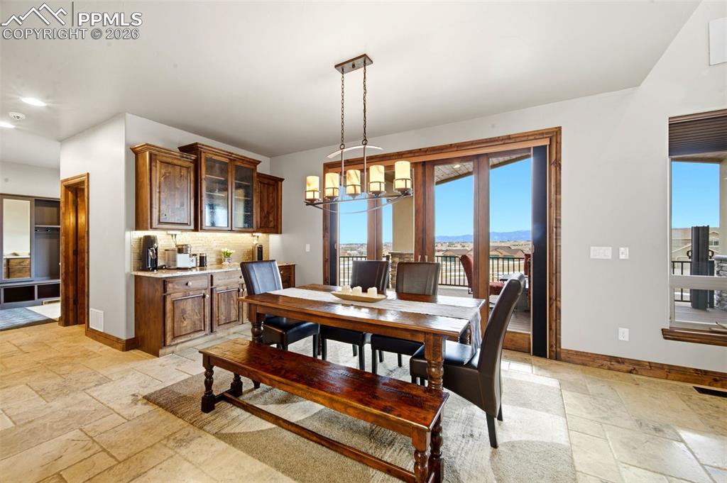 Dining area featuring stone tile flooring and hanging lights