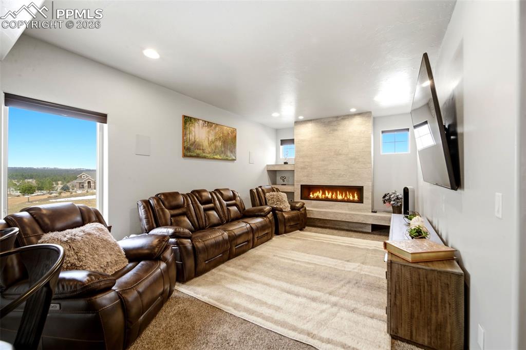 Living room featuring carpet flooring, a fireplace, and recessed lighting