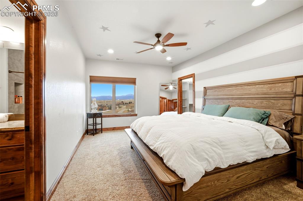 Carpeted bedroom with a ceiling fan, a mountain view, and recessed lighting
