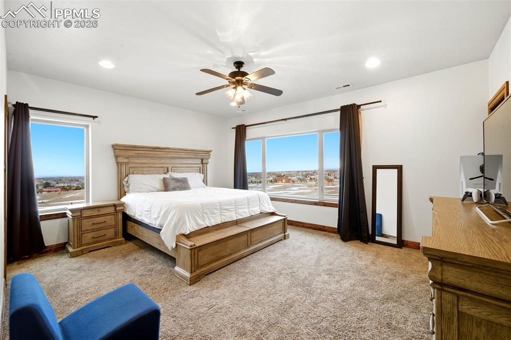 Bedroom with a ceiling fan, light carpet, recessed lighting, and multiple windows