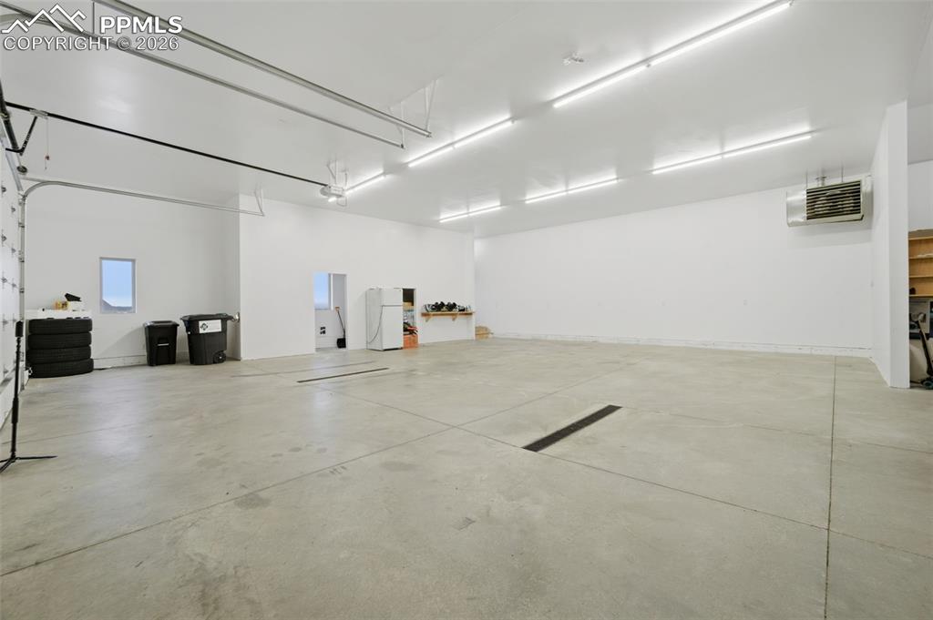 Garage featuring freestanding refrigerator and a heating unit